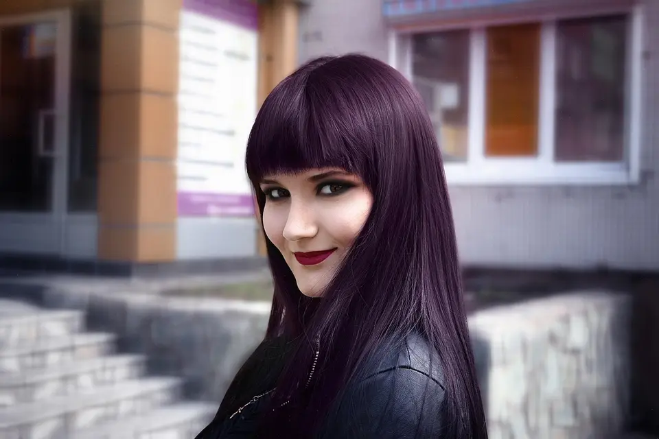 Mujer joven sonriente en un entorno moderno con iluminación violeta